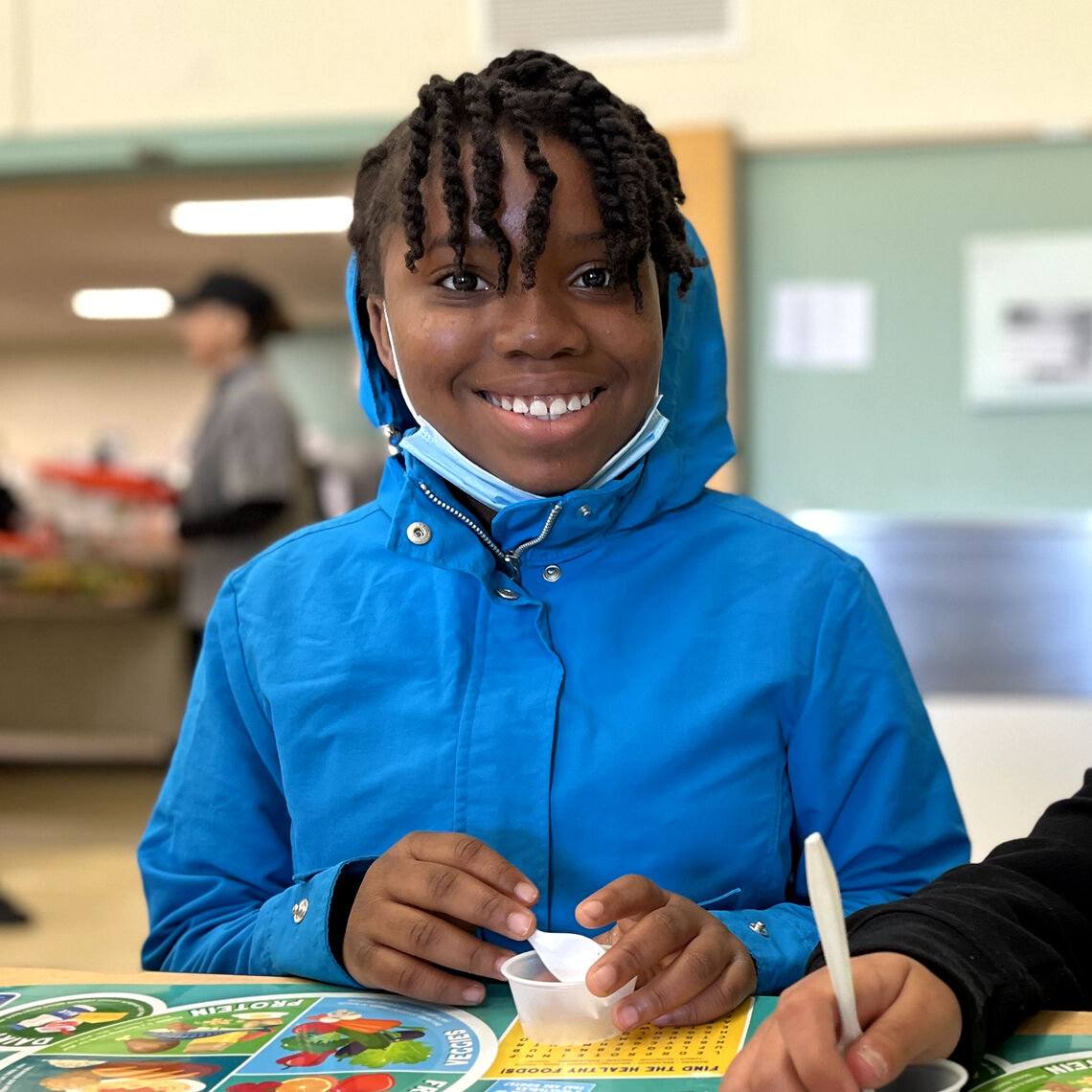 Two girls sit together eating lunch in the cafeteria